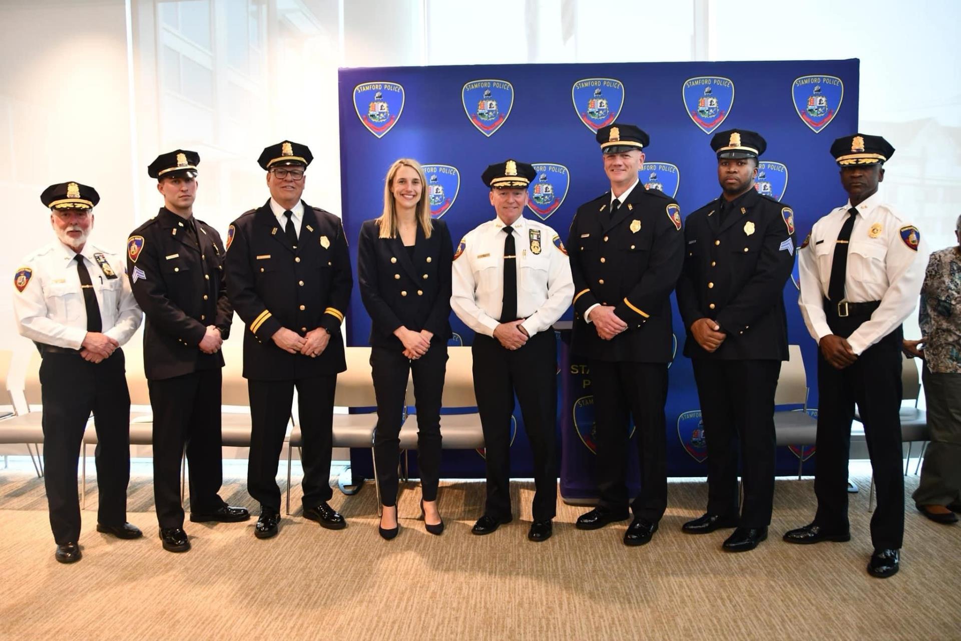 Mayor Simmons smiles with newly promoted police officers and chief shaw