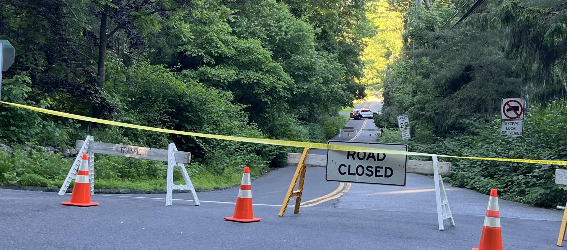 A picture of Mill Road Bridge closed with caution tape and cones in front of the bridge